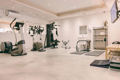 阿尔克马尔Hotel Alkmaar的一间健身房,在白色的房间设有健身器材