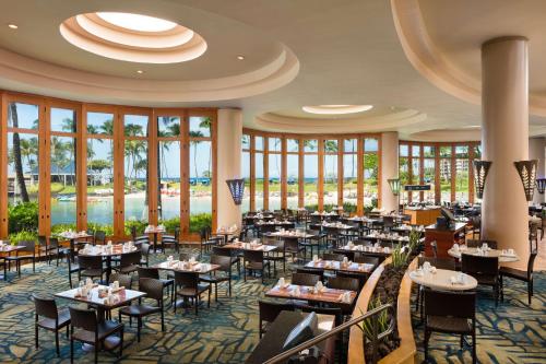 瓦克拉Hilton Grand Vacations Club Ocean Tower Waikoloa Village的用餐室设有桌椅和窗户。