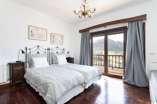 特格斯特Finca Los Geranios的一间卧室设有一张床、一个窗户和一个吊灯。