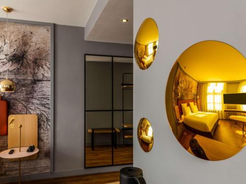 圣奥梅尔布列塔尼酒店的酒店客房的墙上设有大镜子