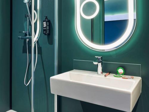 蒙雷里Ibis Montlhery Paris Sud的浴室设有白色水槽和镜子