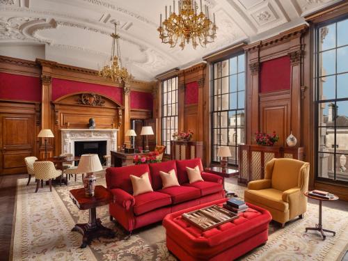 伦敦Raffles London at The OWO的客厅设有红色的沙发和壁炉