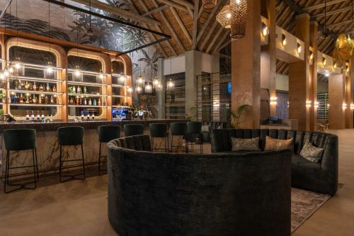 侯斯普瑞特Radisson Safari Hotel Hoedspruit的酒吧配有黑色椅子和吧台