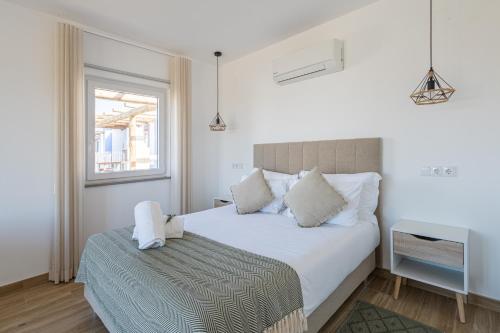 科武港Monte do Cerro的卧室配有白色的床和窗户。
