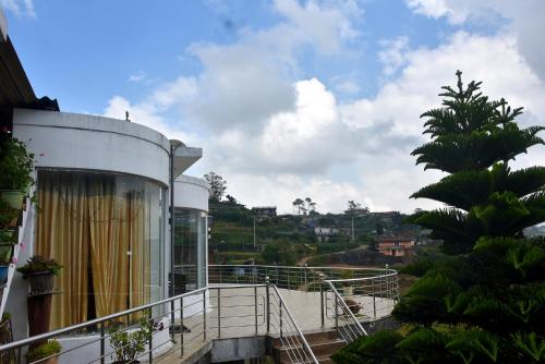 努沃勒埃利耶Nuwaraeliya Konical Villa的棕榈树建筑的阳台