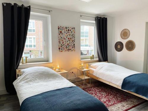 海因斯贝格Ferienwohnung Delta的卧室设有两张床,带两个窗户