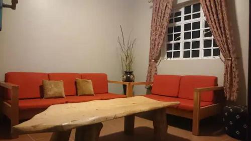 内罗毕Cozy Guesthouse at Farm Escape的客厅配有红色沙发和茶几