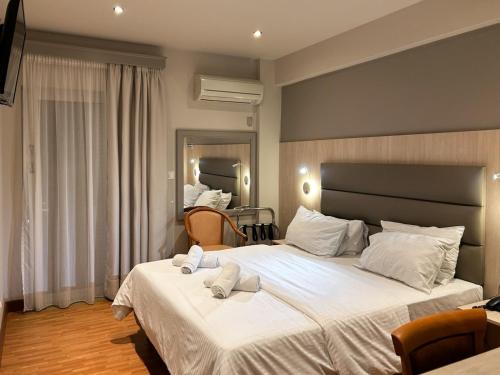 比雷埃夫斯Anemoni Piraeus Hotel的一间卧室配有两张床和白色毛巾。