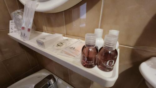 维哥迪法萨Inter Hotel B&B的浴室位于厕所旁的架子上,配有2瓶水