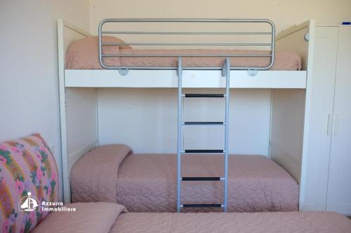 利多迪耶索罗Residence Borgo dei Fiori D03的小型客房设有两张双层床,配有梯子