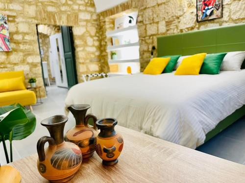 塔尔奎尼亚Casa Soderini的一间卧室,配有一张床和一张桌子上的三个花瓶