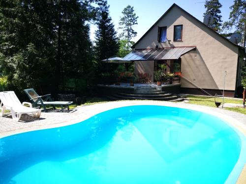 塞格德3 Tó Sziki Szálló的一座大蓝色游泳池,位于房子前