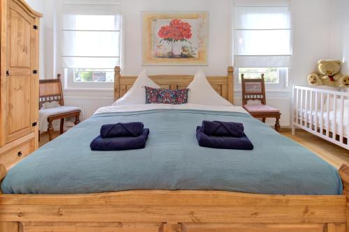 诺伊恩比尔格Familienglück im Schwarzwaldhaus mit Schlossblick的一间卧室配有一张带紫色枕头的大木床