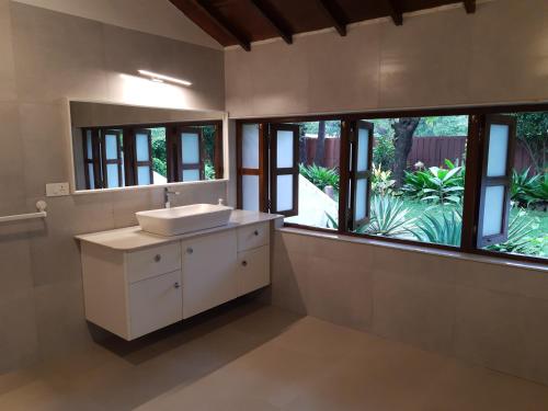 纳加奥恩Banyan House - luxurious 4 bedroom villa on one acre, near the beach的一间带水槽和大窗户的浴室