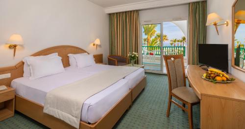 甘达坞伊港康大维港埃尔莫拉蒂酒店的酒店客房配有一张床、一张书桌和一台电视。