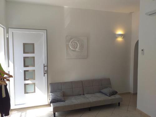 奥尔比亚La casa di May的客厅位于门前,配有沙发