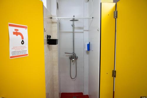 巴塞罗那Onefam Les Corts的浴室设有黄色墙壁和淋浴间