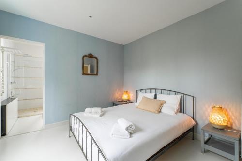 拉特斯特德布赫Magnifique Appartement avec parking a 300m de la Plage的一间卧室配有一张带白色床单和镜子的床