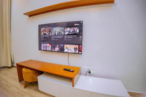 鲁亨盖里Makeri Residence - Musanze , Rwanda的挂在白色墙壁上的电视,配有书桌