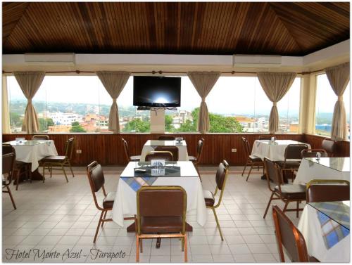 塔拉波托Hotel Monte Azul的餐厅设有桌椅和平面电视。