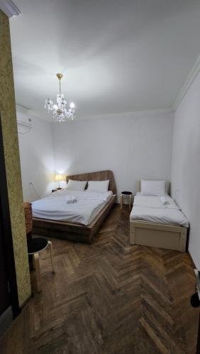 第比利斯Guest House Tbilisi style的一间卧室配有两张床和吊灯。