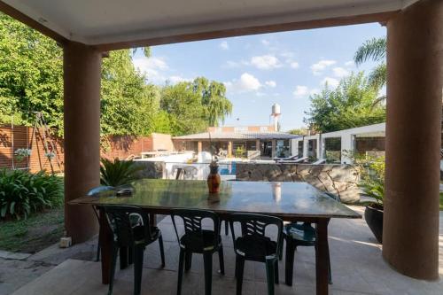 埃塞萨Apart hotel 20 minutes from Minister Pistarini airport with heated pool的一个带桌椅的庭院和一座房子