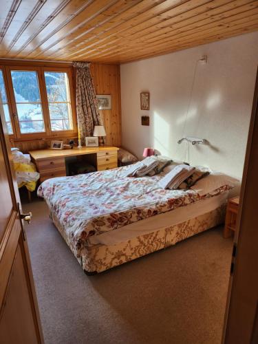 莱迪亚布勒雷Beautiful appartment in Les Diablerets的一间卧室配有一张大床和一张书桌