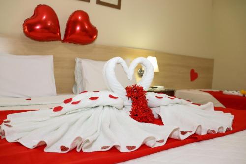 塔曼达雷Hotel Coral Beach的两个穿爱情的天鹅坐在床上
