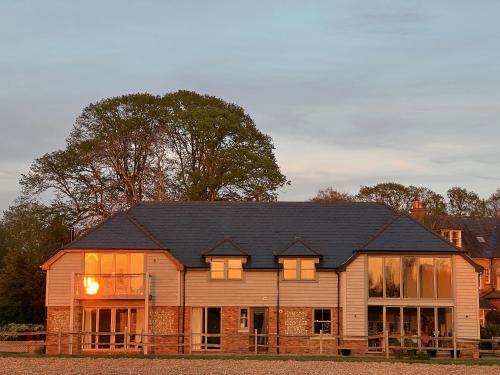 LavantFlint House, Rew Lane, Chichester的一座大型木房子,设有黑色屋顶