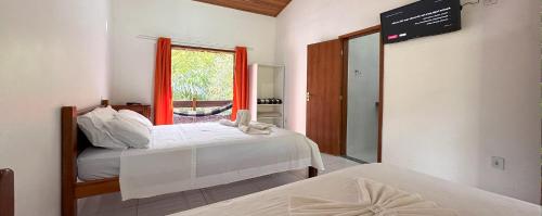 萨纳Pousada J Country的配有窗户和镜子的客房内的两张床