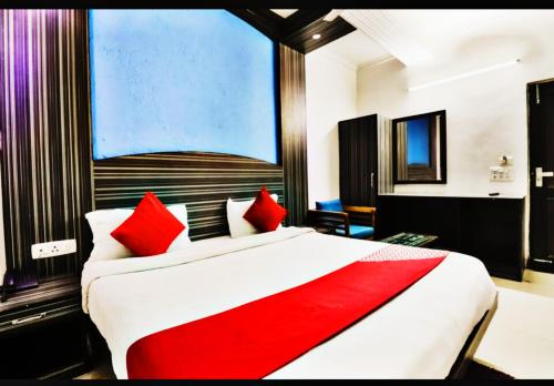 新德里Hotel Global Stay Near Delhi Airport的一间卧室配有一张带红色枕头的大床