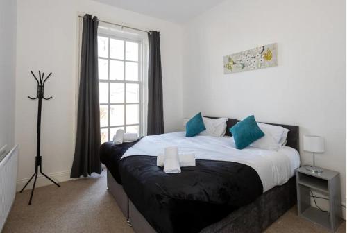 伯肯黑德Devonshire Road - Apartment 1的一间卧室配有一张带蓝色枕头的大床