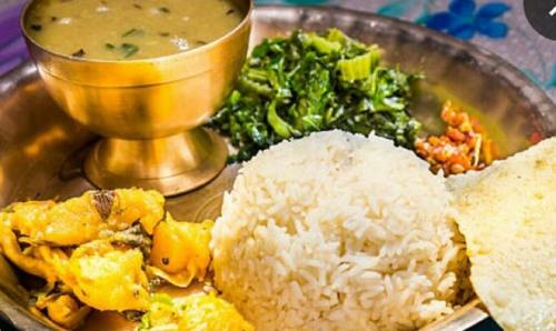 德奥加尔SHIVAY Guest House的盘子上放着米饭和蔬菜,还有一碗汤