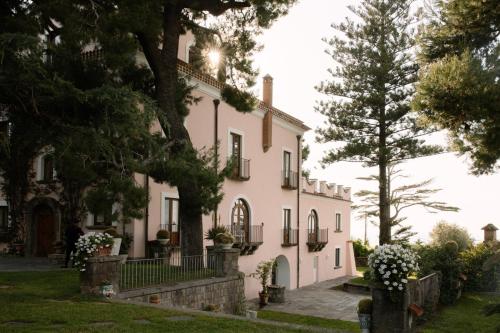 索伦托卡波圣福尔图纳塔农家乐的前面有树木的大白色房子