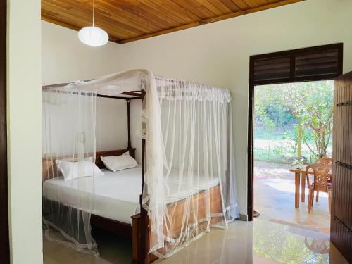 本托塔Rathna Villas的一间卧室设有天蓬床和庭院。