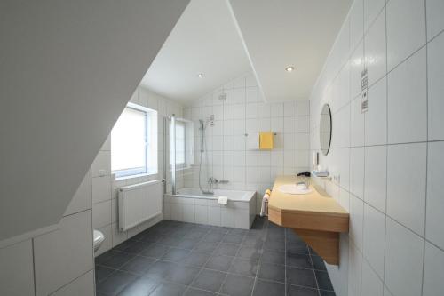 菲施巴赫莱斯科勒瓦莱夫酒店的一间带水槽、浴缸和卫生间的浴室