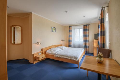 菲施巴赫莱斯科勒瓦莱夫酒店的酒店客房配有一张床铺和一张桌子。