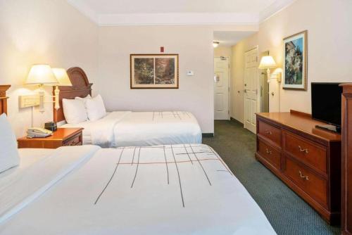 迈尔斯堡La Quinta Inn and Suites Fort Myers I-75的酒店客房,配有床和电视