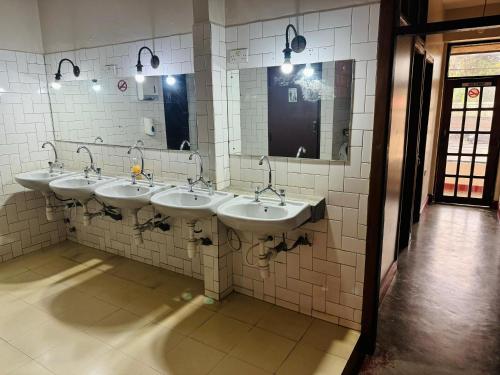 阿鲁沙Arusha Backpackers Hotel的公共浴室里的一排盥洗盆