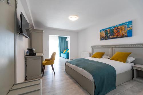 Sub CoastăSky Rooms by Volo Guest House的一间卧室配有一张床和一张黄色椅子