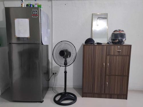 TagumVin's Place Rentals - Studio Unit的冰箱和镜子旁的风扇