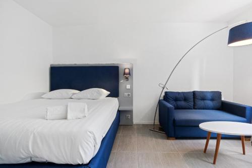 洛桑Sallaz Residence by Homenhancement的一间卧室配有一张床和一张蓝色的沙发