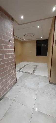 卡萨布兰卡Appart casa的一间设有砖墙和白色瓷砖地板的客房