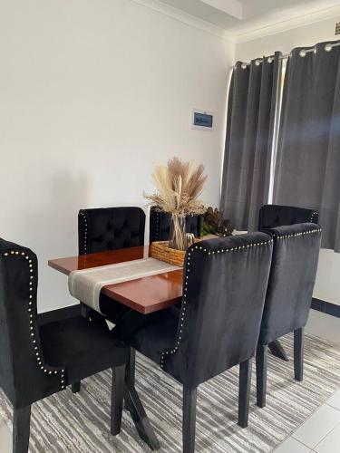 利隆圭Queen City Homes的餐桌、黑色椅子和桌子