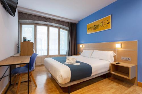 毕尔巴鄂Casual Arriaga的酒店客房配有一张床铺、一张桌子和一张书桌。
