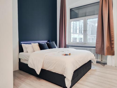 埃森o Loft Studio I 50qm I zentral & ruhig I Messe HBF nah的一间卧室配有一张蓝色墙壁的床
