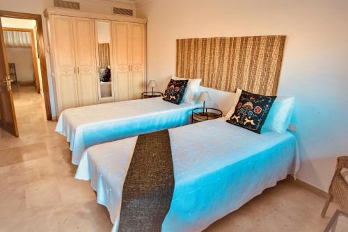 拉普拉亚蒂陶洛M&F Golf Views. Walk to Beach的配有蓝色床单的客房内的两张床