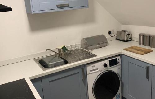 韦克菲尔德Sandal Park View - Duplex Relocations的厨房柜台设有水槽和洗碗机。