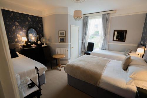 多佛尔迪乌豪宅酒店的一间卧室配有两张床、一张桌子和一面镜子