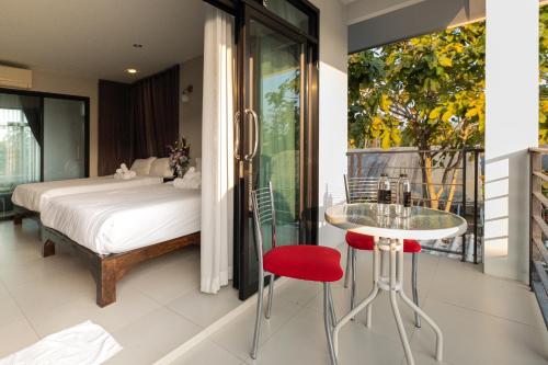 清迈达旺之家住宿加早餐旅馆的一间卧室配有一张床和一张桌子及红色凳子